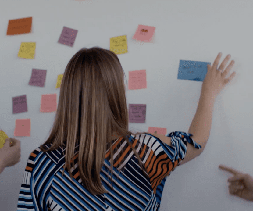 employee putting some post its on a board